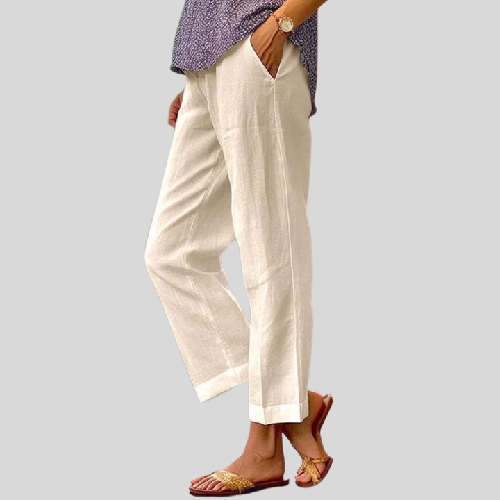 Woman wearing relaxed straight-leg pants with a soft top, standing in soft daylight.