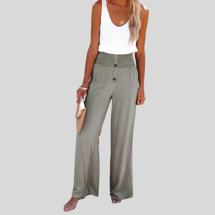 A woman in high-waisted loose wide-leg pants with subtle button detailing, styled for an elegant everyday look.