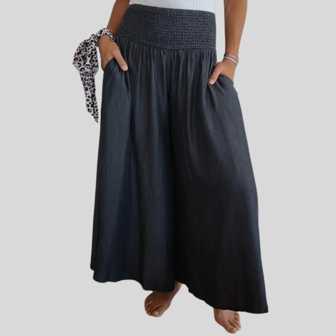 Woman wearing high-waist wide-leg pants with a tucked-in blouse, mid-stride.