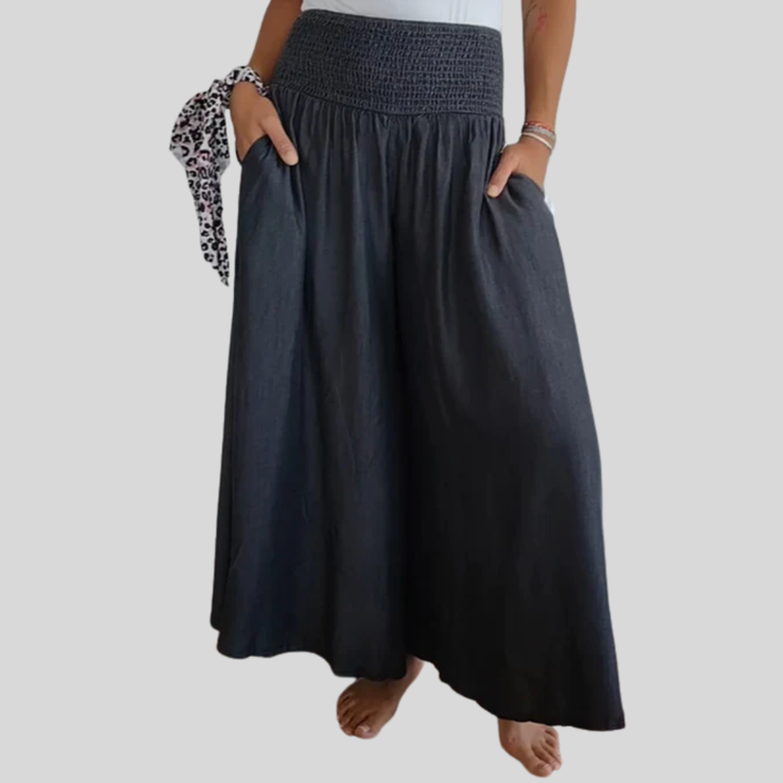Woman wearing high-waist wide-leg pants with a tucked-in blouse, mid-stride.