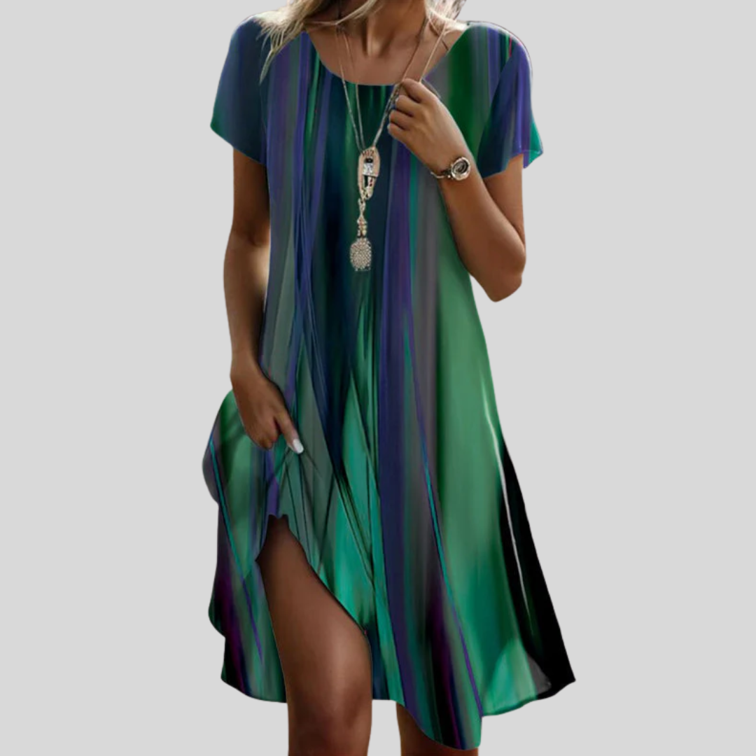 Woman wearing the Vanessa™ multicoloured gradient boho midi dress, walking outdoors with the skirt flowing around her.