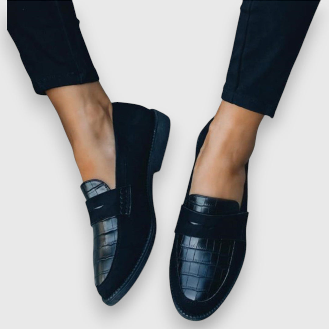 A woman wearing elegant flat loafers with a refined finish