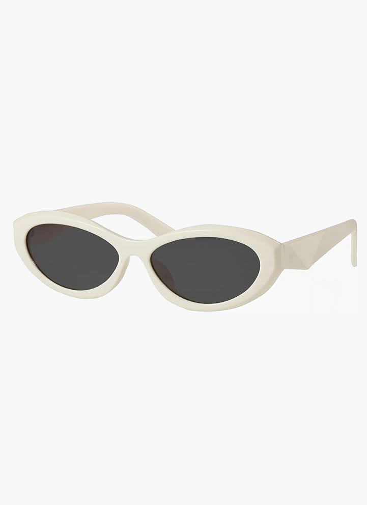 A woman wearing minimalist oval vintage sunglasses on a sunny day.
