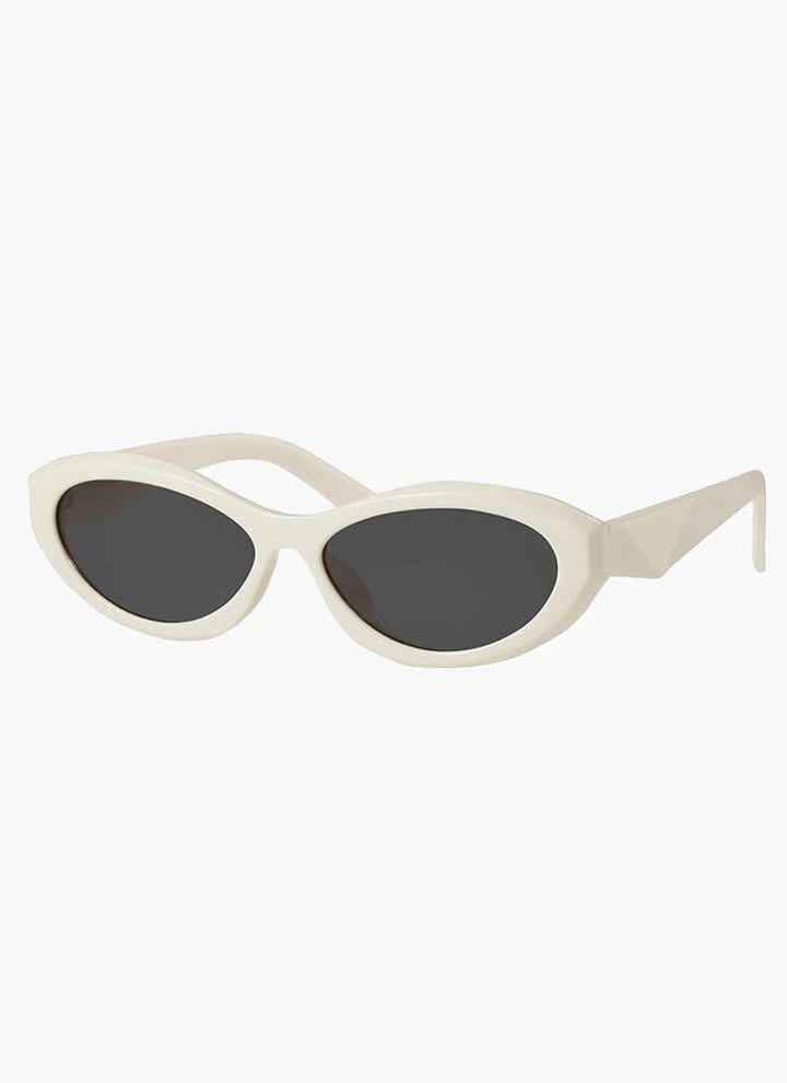 A woman wearing minimalist oval vintage sunglasses on a sunny day.