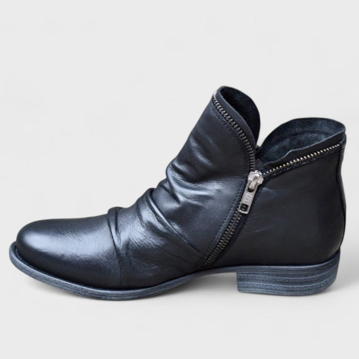 Woman wearing purple comfort ankle boots with jeans on a city street.