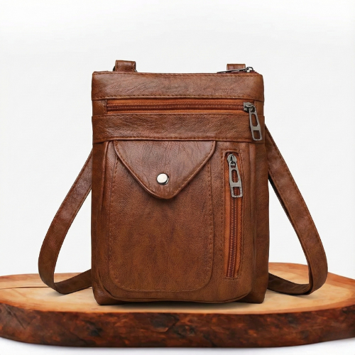 A woman wearing a compact vintage crossbody bag across her body while walking through town.