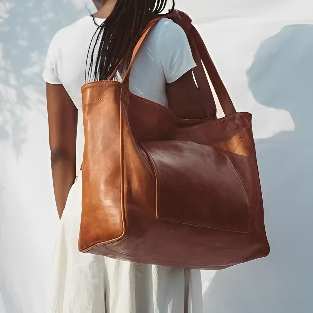 A woman carrying a roomy dark brown everyday handbag on her shoulder during a busy day.