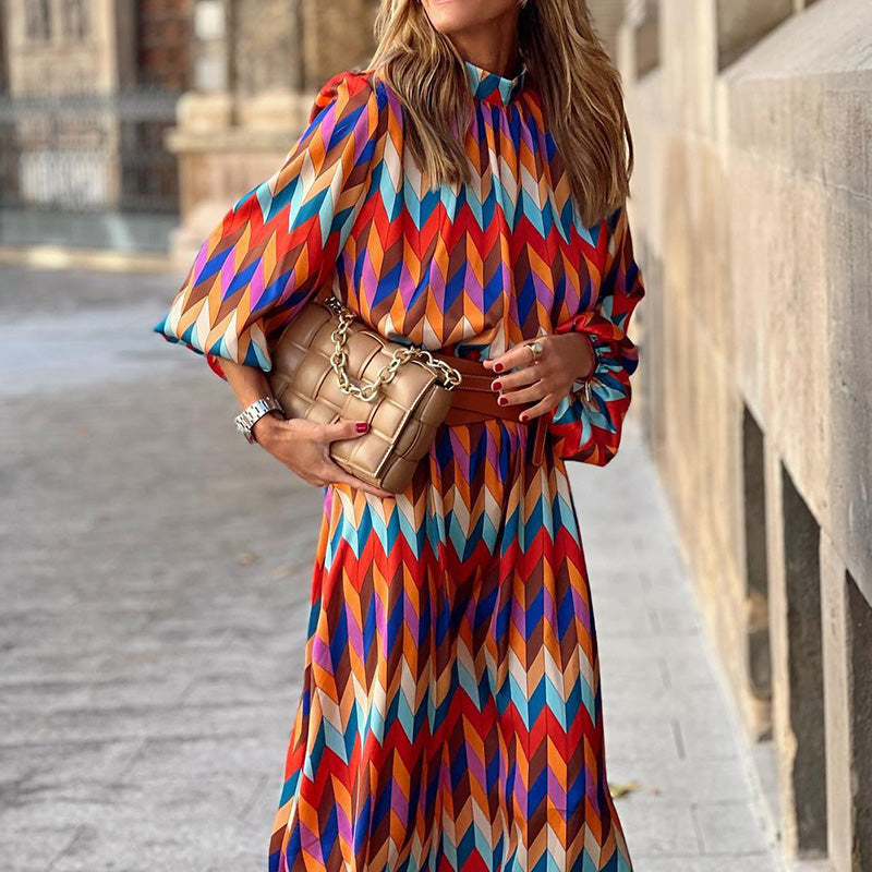 Woman in the Caroline geometric print maxi dress with a high neckline and puff sleeves, walking through a city street.