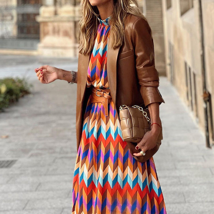 Woman in the Caroline geometric print maxi dress with a high neckline and puff sleeves, walking through a city street.