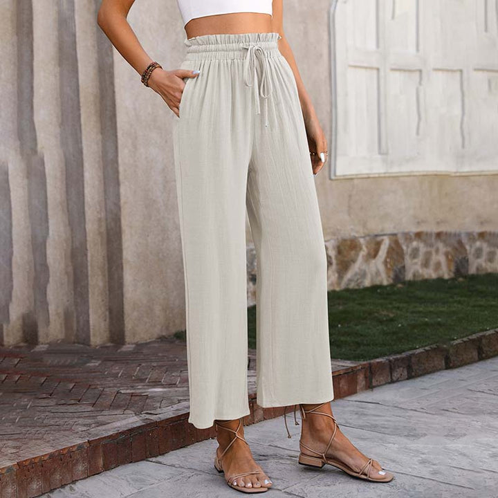 A woman in light cropped wide-leg pants styled with sandals for a relaxed summer look.