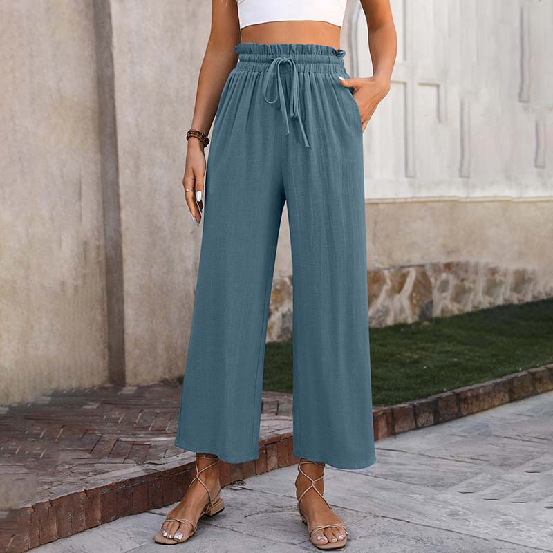 A woman in light cropped wide-leg pants styled with sandals for a relaxed summer look.