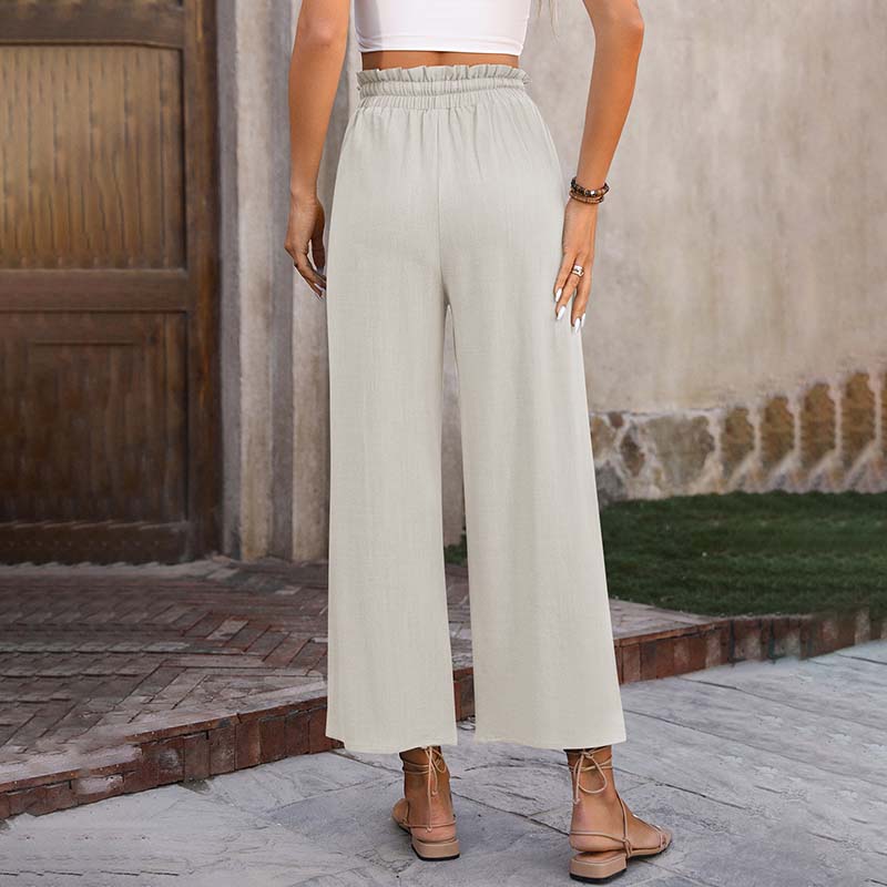 A woman in light cropped wide-leg pants styled with sandals for a relaxed summer look.