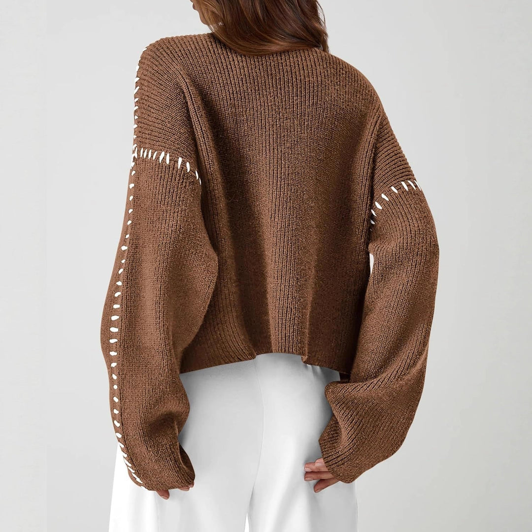 A woman wearing an oversized mock-neck sweater with whipstitch detailing, cosy and stylish.
