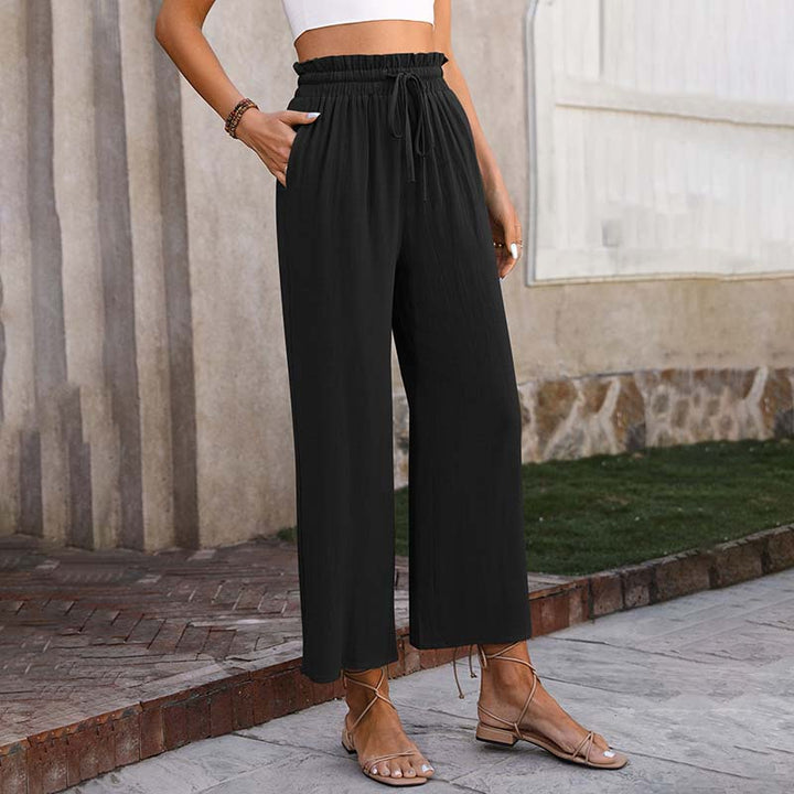 A woman in light cropped wide-leg pants styled with sandals for a relaxed summer look.