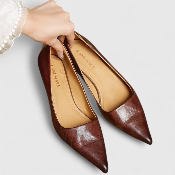 A woman in classic black pointed-toe comfort heels moving easily from office to evening.