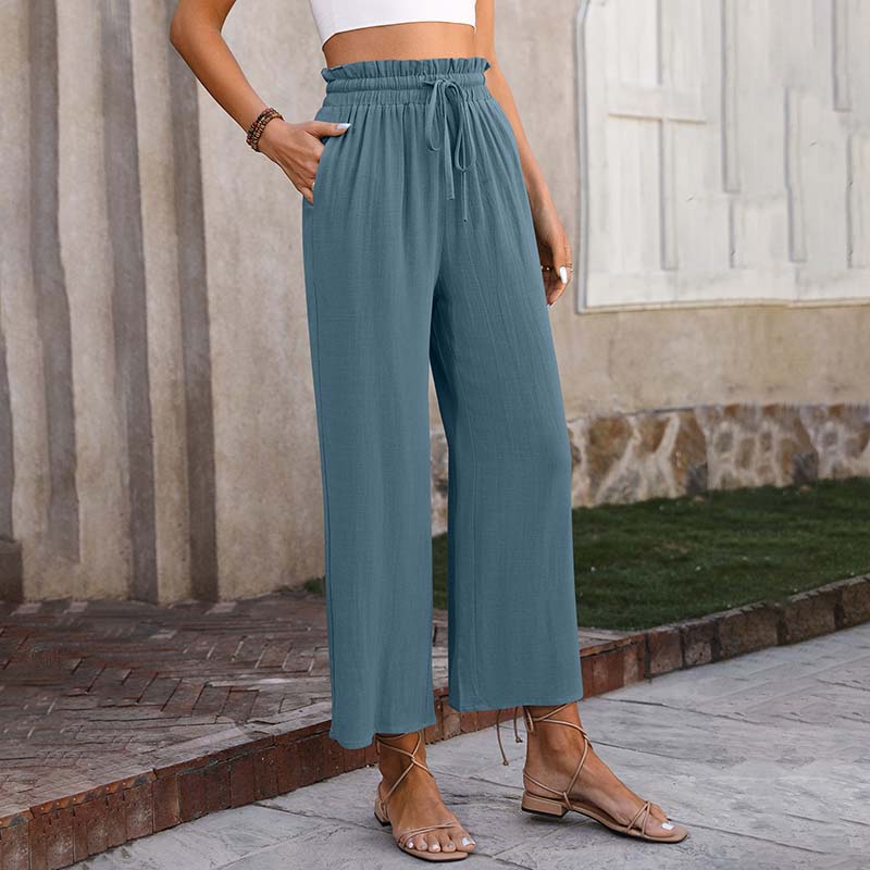 A woman in light cropped wide-leg pants styled with sandals for a relaxed summer look.