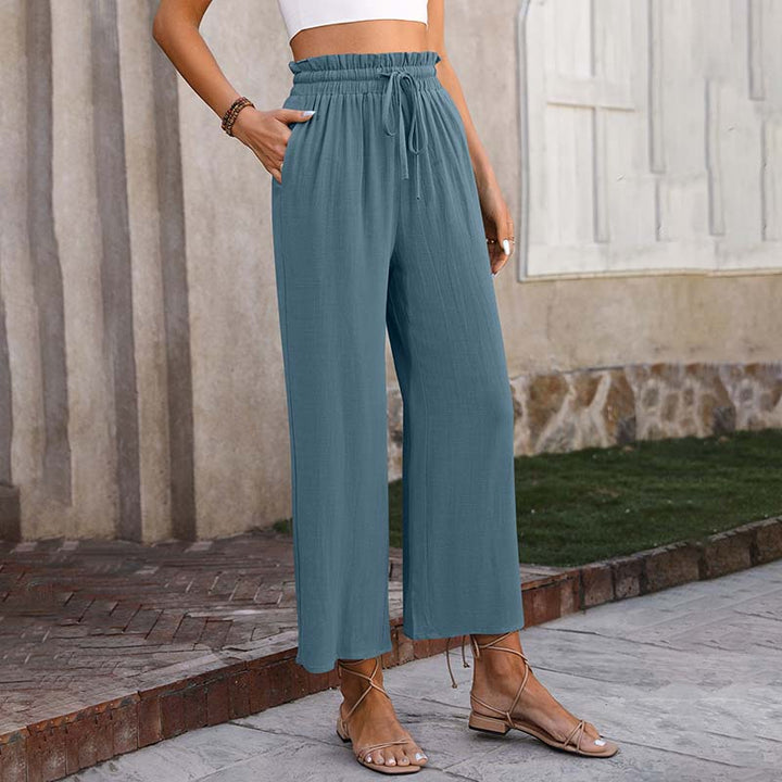 A woman in light cropped wide-leg pants styled with sandals for a relaxed summer look.