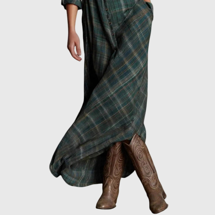 Woman wearing a long green check button-through maxi shirt dress with a collar and pockets, styled with boots.