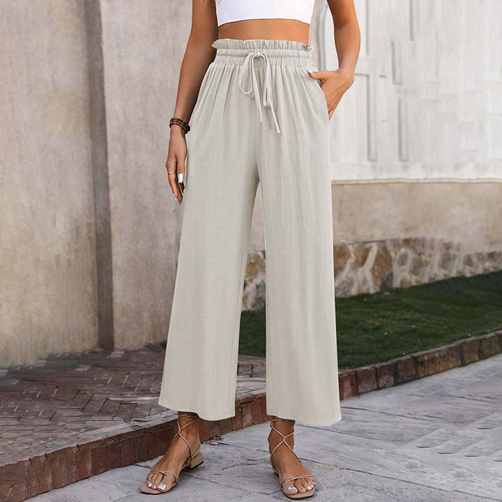 A woman in light cropped wide-leg pants styled with sandals for a relaxed summer look.