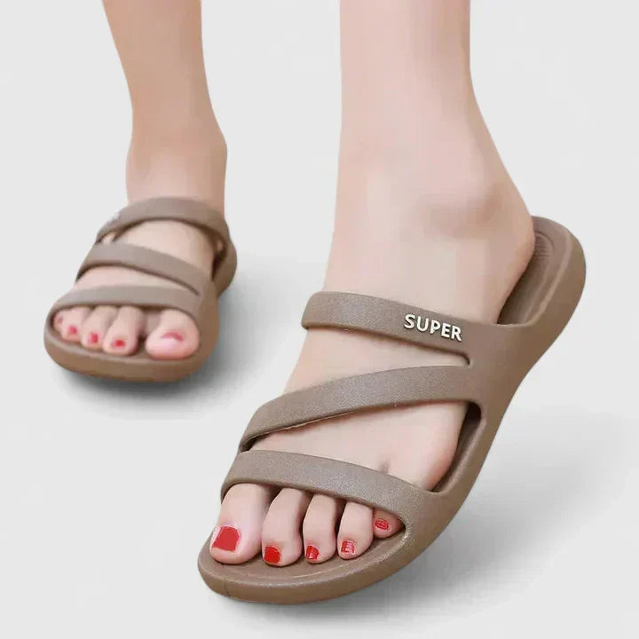 A woman walking confidently outdoors in supportive, cushioned orthopaedic sandals.