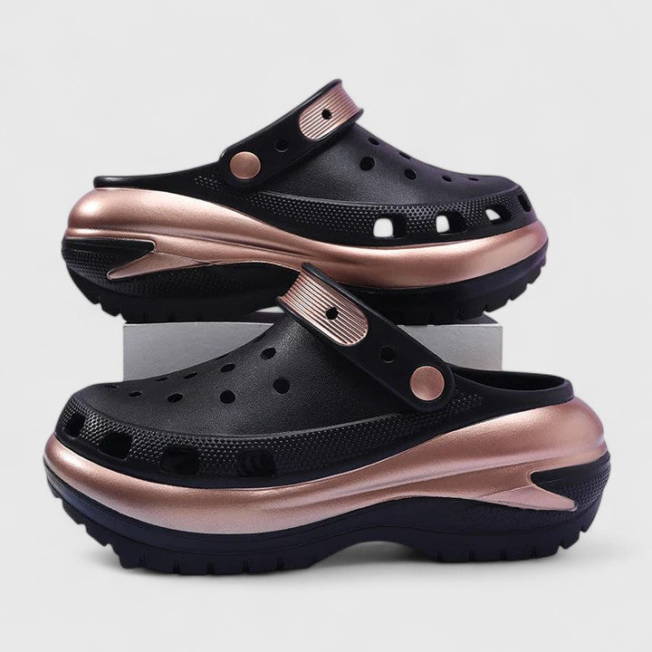 A woman walking comfortably outdoors wearing soft, cushioned orthopaedic clogs with a gentle metallic sheen.