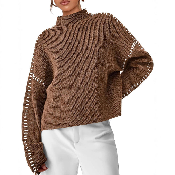 A woman wearing an oversized mock-neck sweater with whipstitch detailing, cosy and stylish.