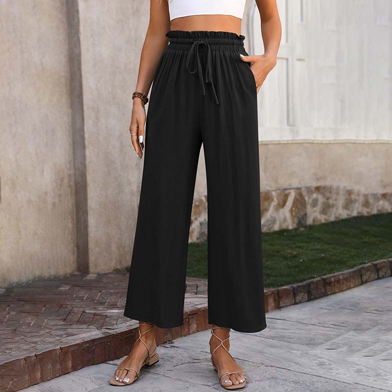 A woman in light cropped wide-leg pants styled with sandals for a relaxed summer look.