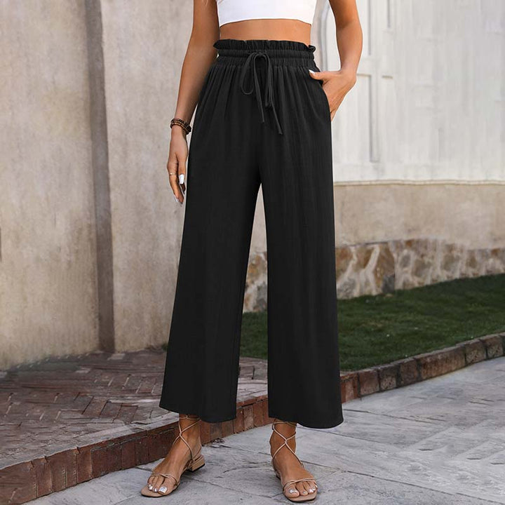 A woman in light cropped wide-leg pants styled with sandals for a relaxed summer look.