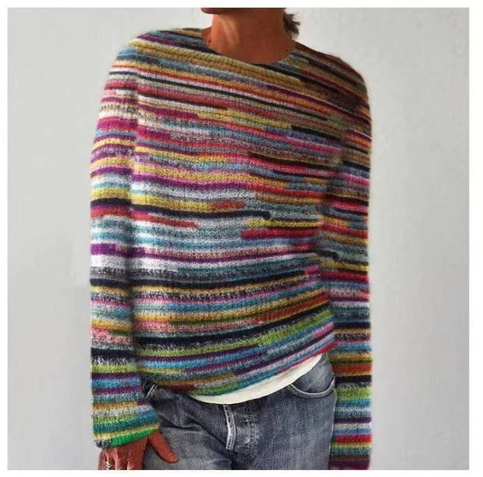 A woman wearing a soft sweater covered in bright multicoloured horizontal stripes, relaxed and warm.