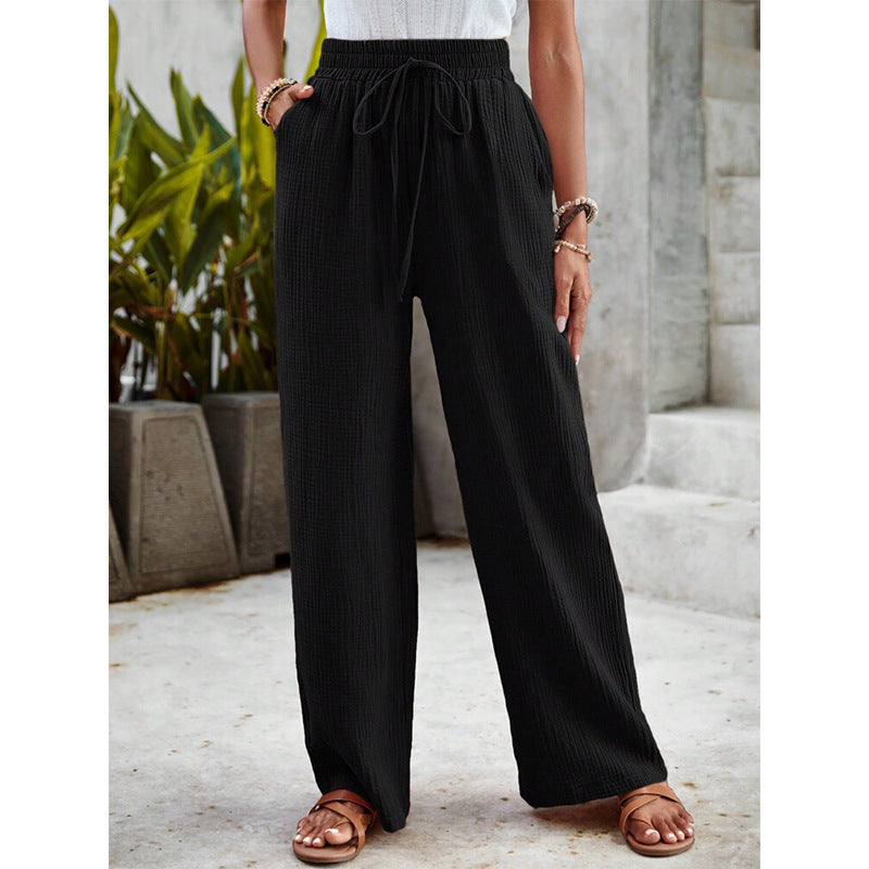 A woman in relaxed wide-leg pants with a drawstring waist, styled for an easy casual look.