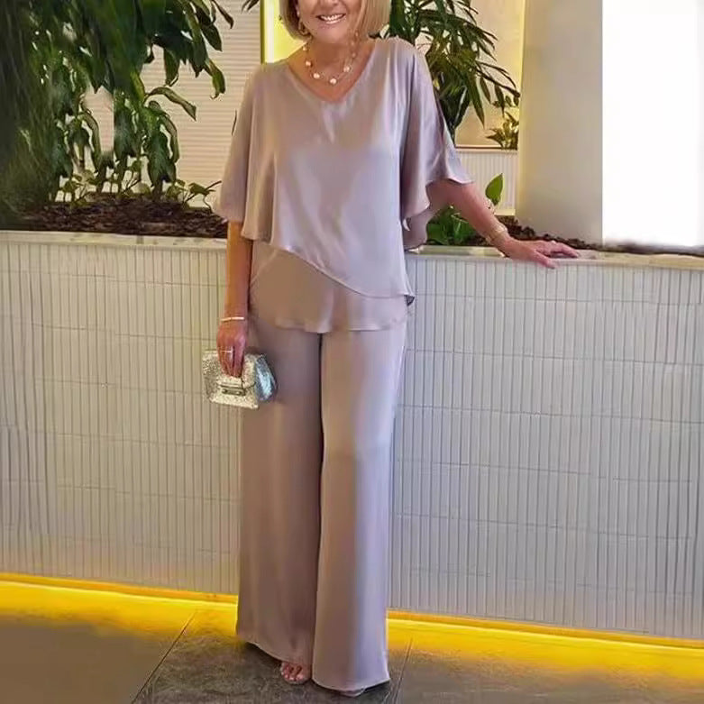 A woman wearing an asymmetric flowing top with matching wide-leg pants.