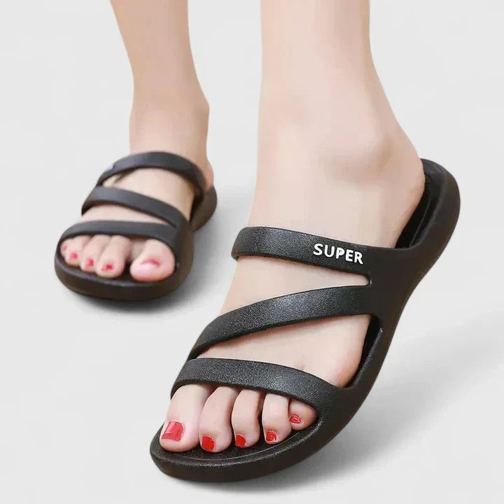 A woman walking confidently outdoors in supportive, cushioned orthopaedic sandals.