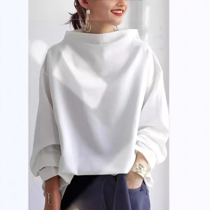 A woman wearing a soft funnel neck sweater styled with jeans for a relaxed elegant look.