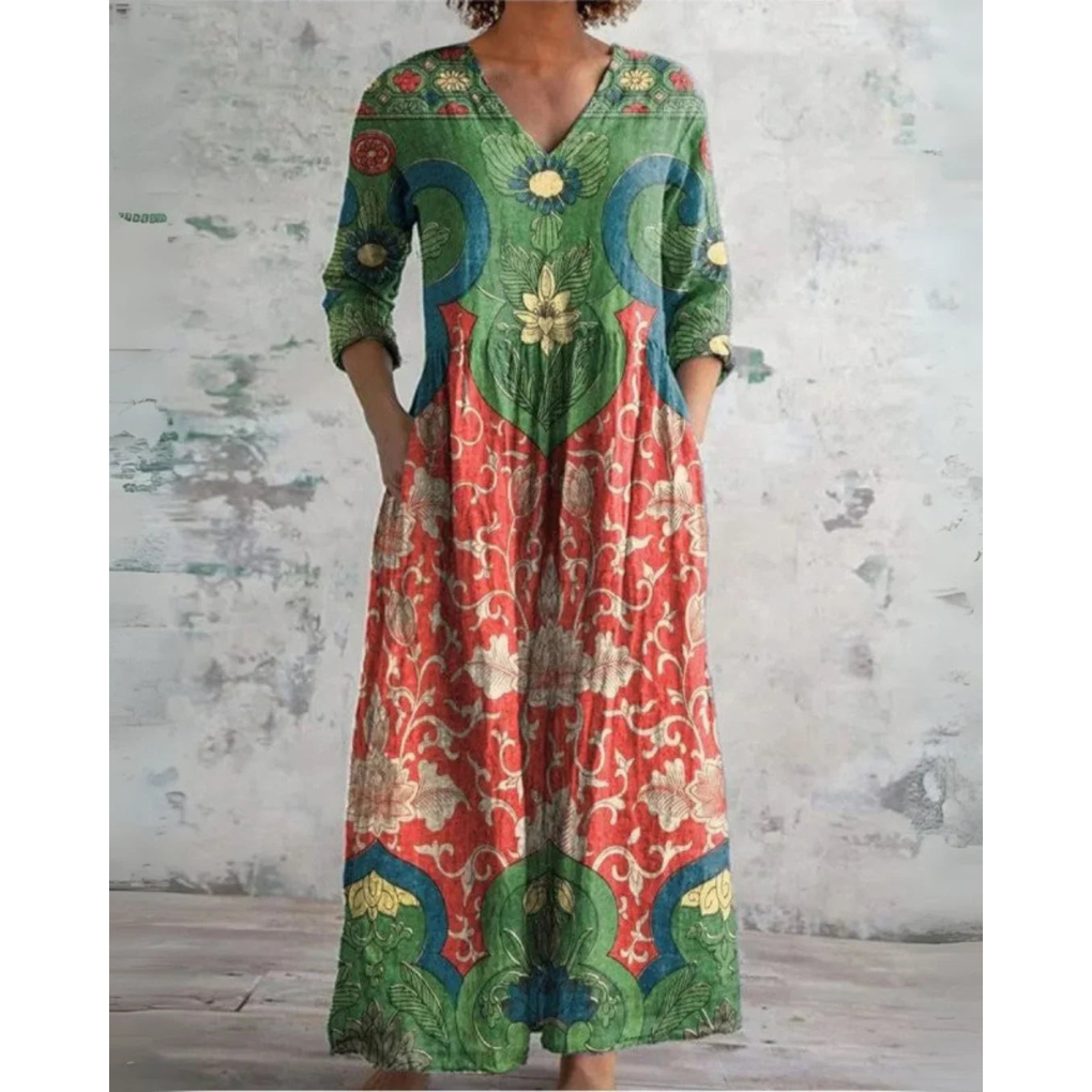 A woman wearing the Brenda vintage floral maxi dress with a gathered waist and flowing skirt at an outdoor celebration.
