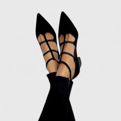A woman in classic black heels walking confidently through the city on an everyday outing.