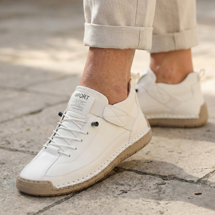A woman wearing white lace-up orthopaedic sneakers with an adjustable strap.