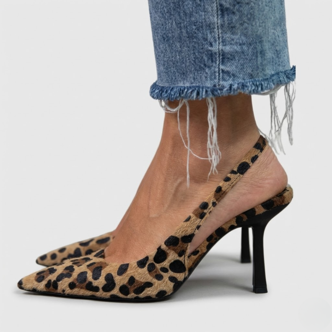 A woman wearing leopard-print comfort heels, standing confidently in an elegant everyday outfit.