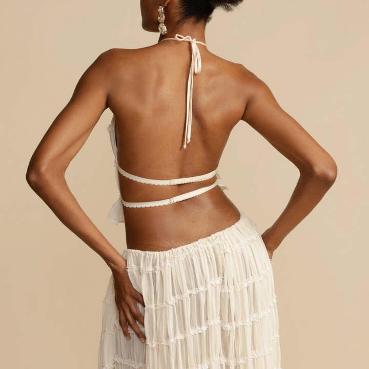 A woman wearing a strappy top with a matching summer skirt