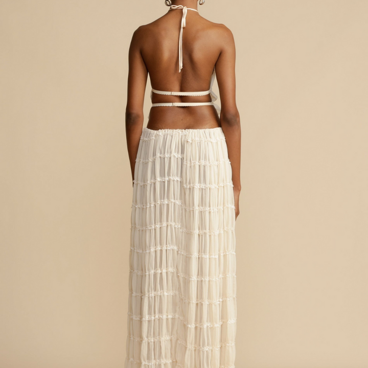 A woman wearing a strappy top with a matching summer skirt