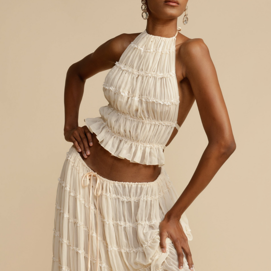 A woman wearing a strappy top with a matching summer skirt