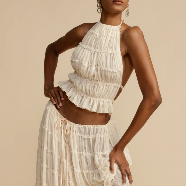 A woman wearing a strappy top with a matching summer skirt