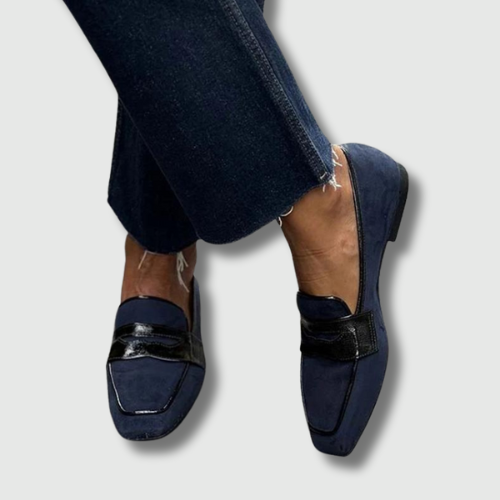 A woman wearing smart blue loafers on a polished day out.