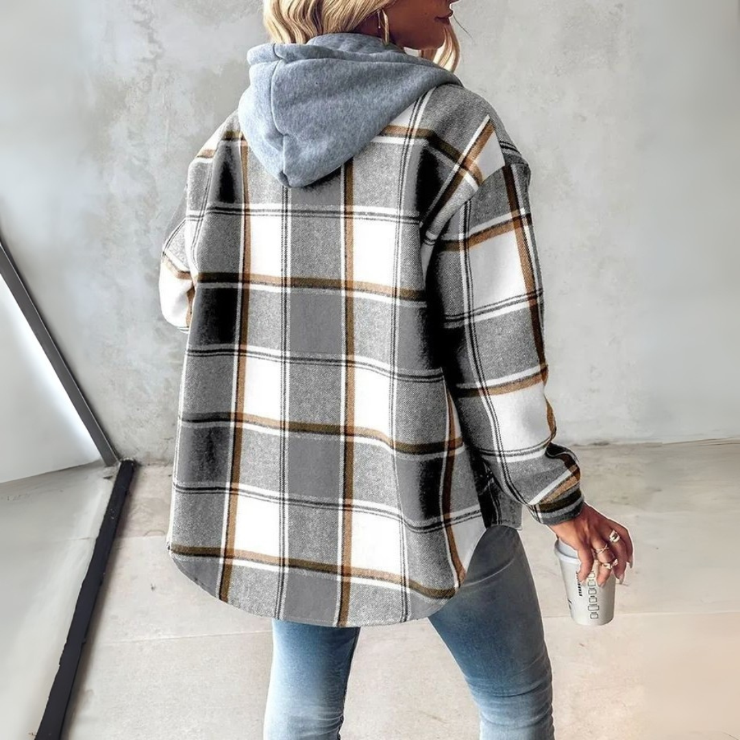 A woman wearing a grey and white checked hooded jacket with a button front