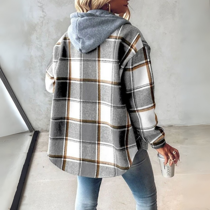 A woman wearing a grey and white checked hooded jacket with a button front