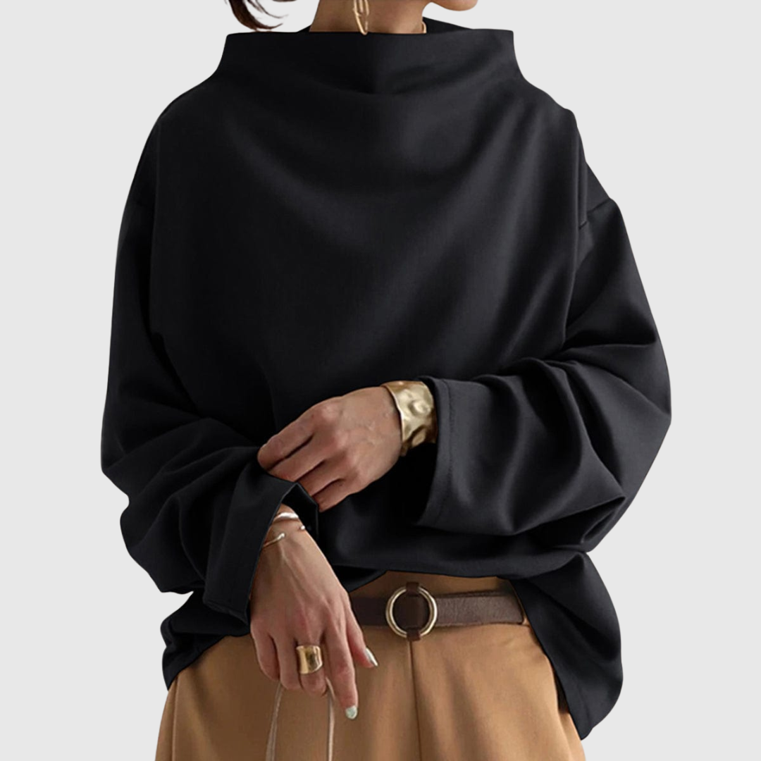 A woman wearing a soft funnel neck sweater styled with jeans for a relaxed elegant look.