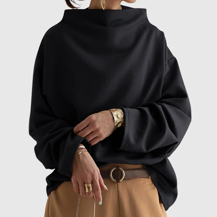 A woman wearing a soft funnel neck sweater styled with jeans for a relaxed elegant look.
