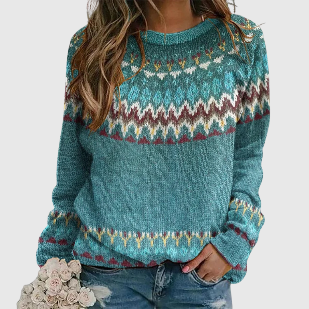 A woman wearing a teal sweater with a colourful retro zigzag pattern and a round neck, relaxed and cosy for fall.