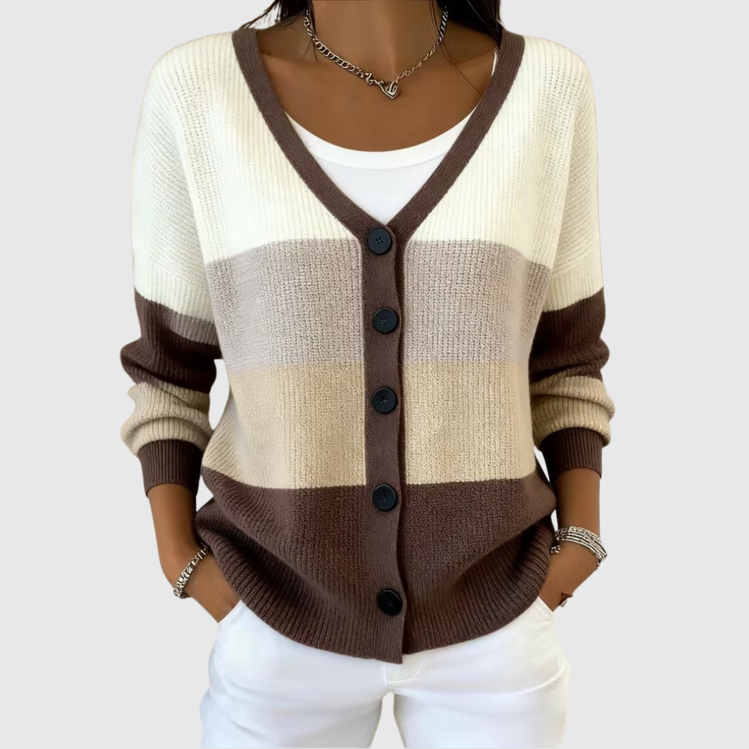 A woman wearing a colour block button cardigan in cream, sand and deep brown over a white top.