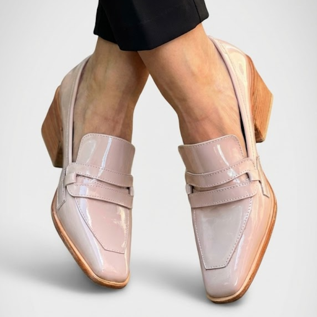 A woman wearing shimmering slip-on loafers with a subtle glow, dressed for an evening out.