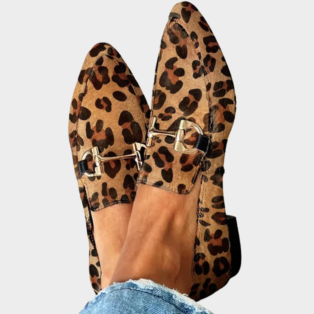 A woman wearing leopard print slip-on loafers, styled for an easy day in the city.